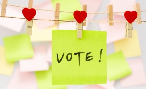 vote written on post-it note pinned with hearts