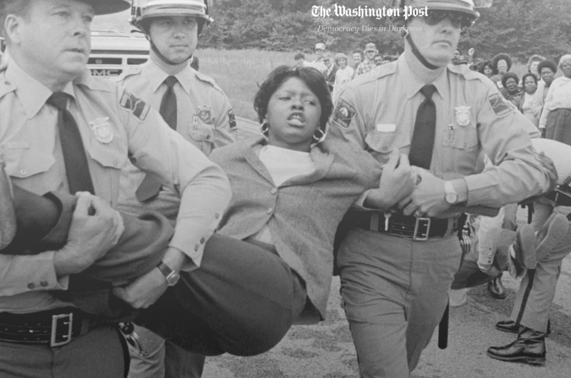 newspaper of protestor carried by police officers